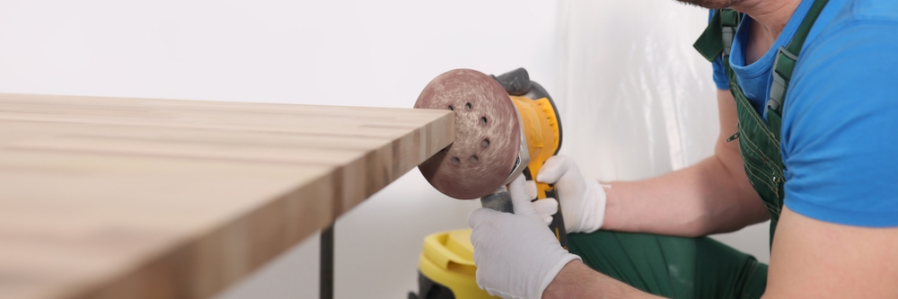 Concentrated,Worker,Polishes,Wooden,Board,Edge,With,Grinding,Tool,In